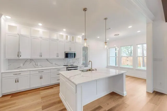 a large kitchen with kitchen island a sink appliances and a counter top space