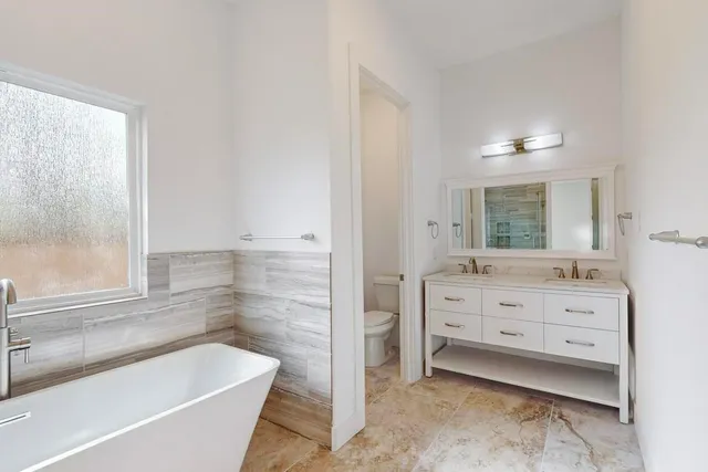 a bathroom with a bathtub sink and mirror