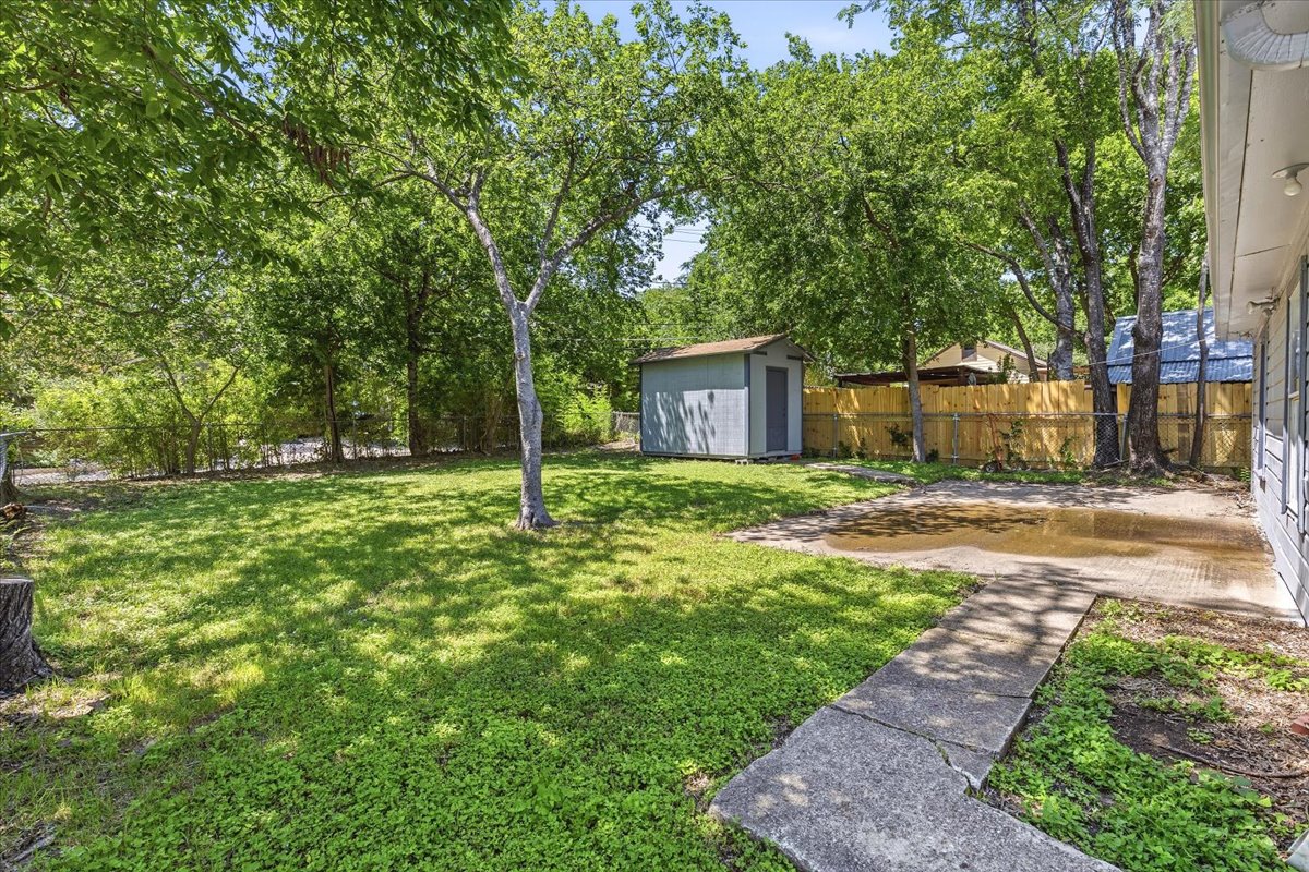 4900 Duval Street Austin, TX 78751 - Photo 8 of 25 Wide backyard view from the 49th Street side of the property, highlighting the depth of the lot, mature tree canopy, and open yard area. The corner positioning and alley access provide additional flexibility for future site planning, parking, or improvements.
