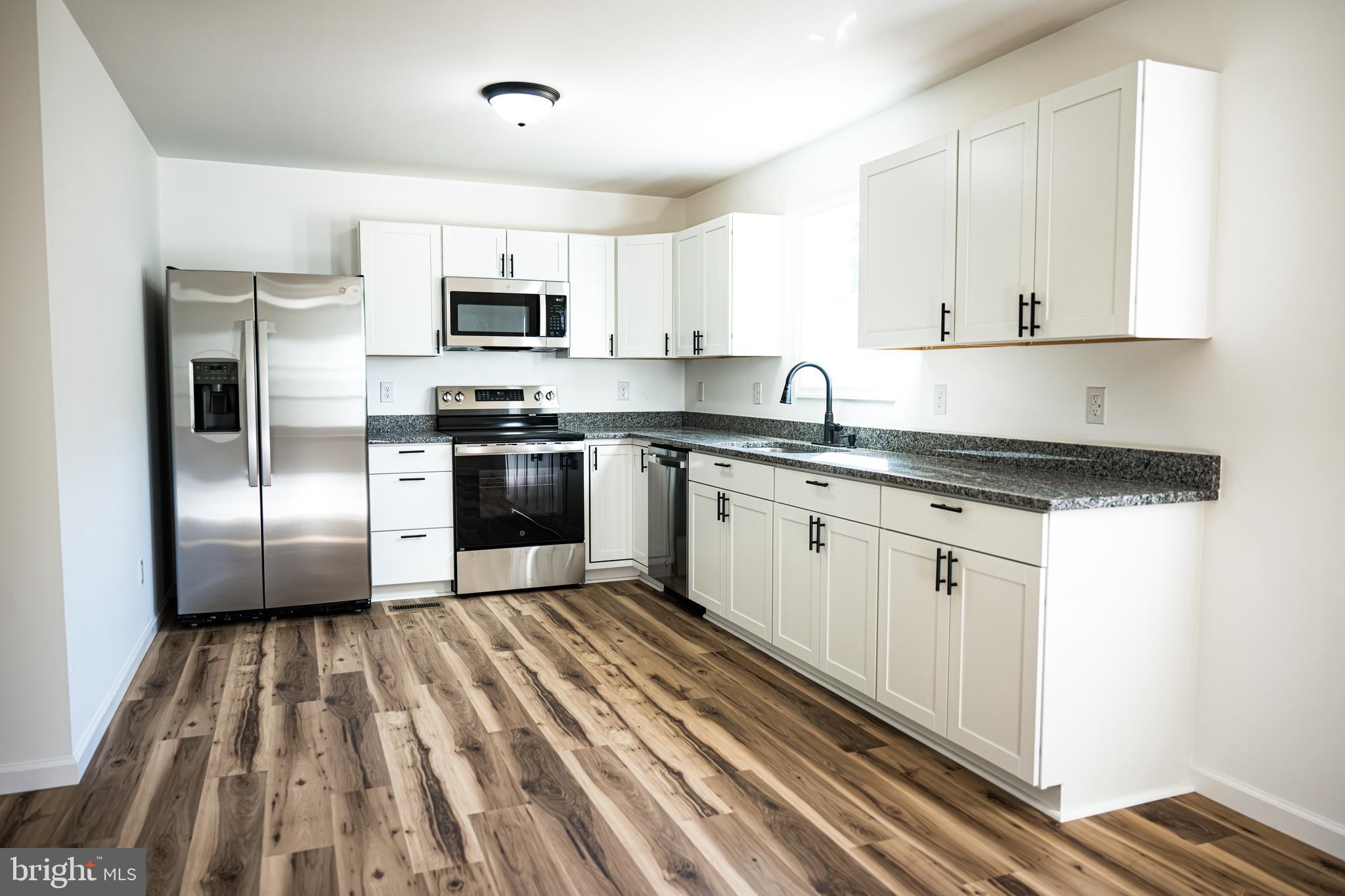 100 Bumpass Road Bumpass, VA 23024 - Photo 5 of 16 a kitchen with stainless steel appliances granite countertop a refrigerator sink and white cabinets