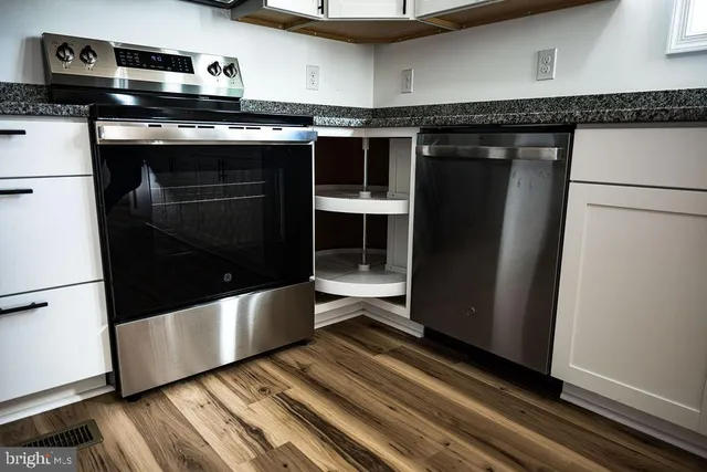 a kitchen with granite countertop a stove and a refrigerator