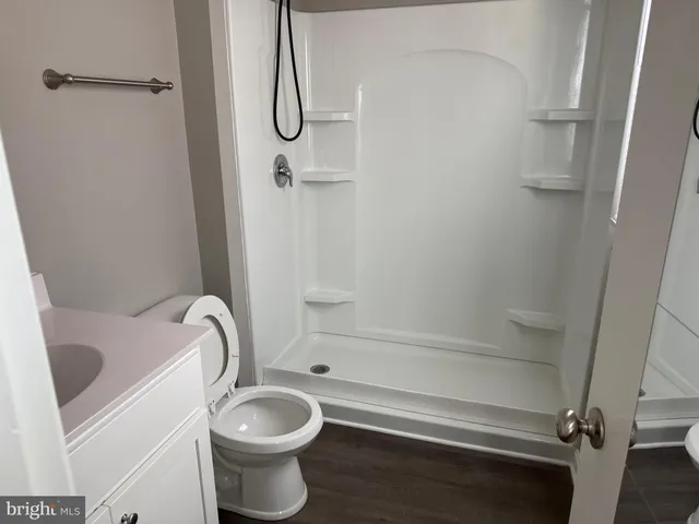 a bathroom with a sink a toilet and shower