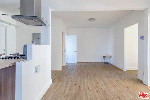 a view of a kitchen with refrigerator and wooden floor