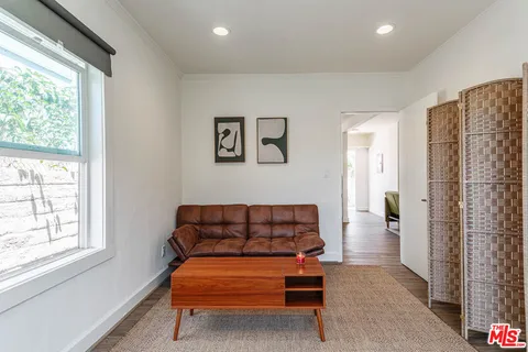 a living room with furniture a couch and two windows