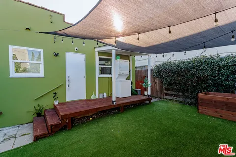 a backyard of a house with barbeque oven table and chairs