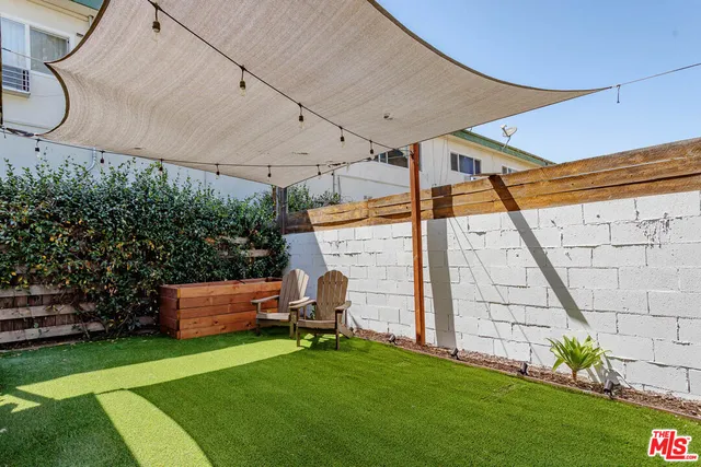 a view of a backyard with table and chairs potted plants