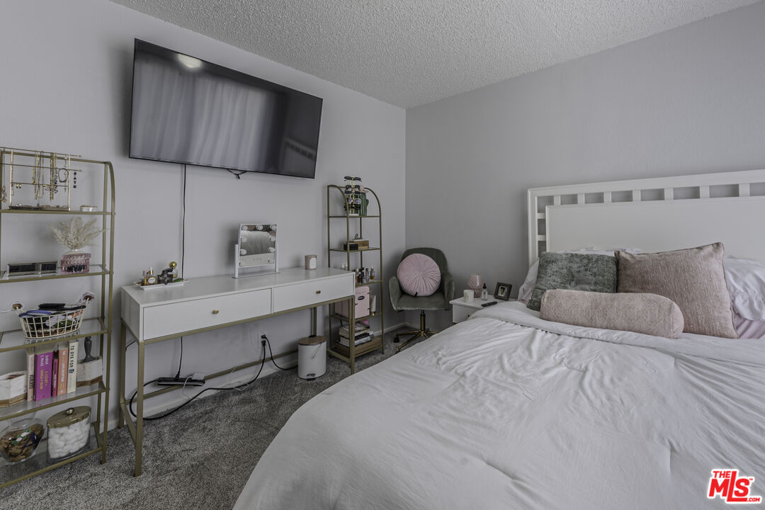 849 East Victoria Street, Unit 101 Carson, CA 90746 - Photo 11 of 19 a bedroom with a bed a dresser and many windows