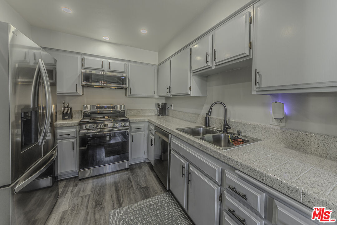 849 East Victoria Street, Unit 101 Carson, CA 90746 - Photo 6 of 19 a kitchen with stainless steel appliances a sink stove and refrigerator