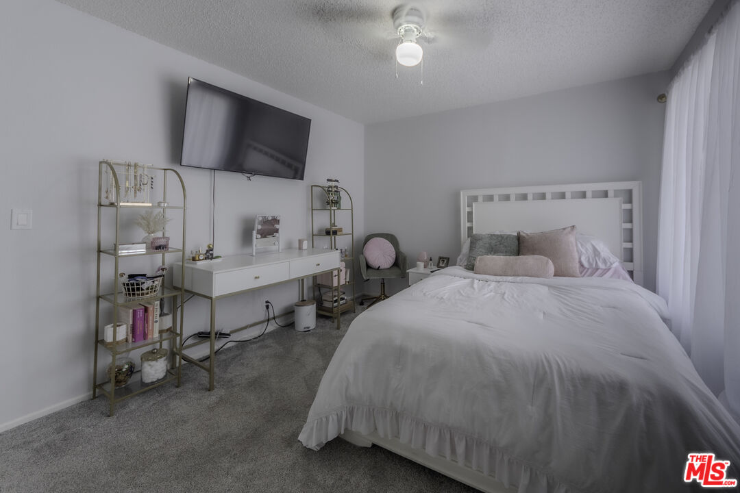 849 East Victoria Street, Unit 101 Carson, CA 90746 - Photo 9 of 19 a bedroom with bed and a chandelier