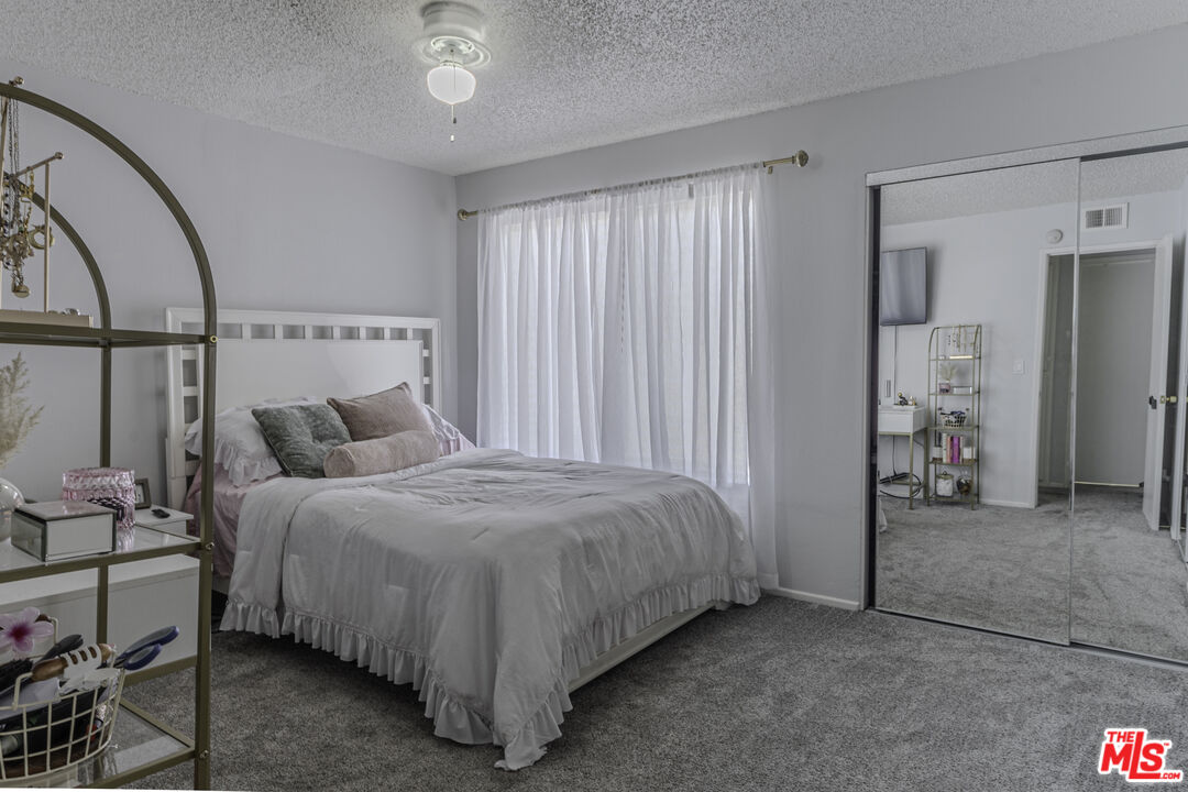 849 East Victoria Street, Unit 101 Carson, CA 90746 - Photo 10 of 19 a bedroom with a bed and a mirror