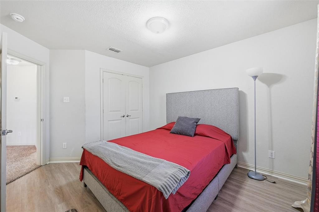6913 Sandshell Boulevard Fort Worth, TX 76137 - Photo 11 of 24 a bedroom with a bed and wooden floor