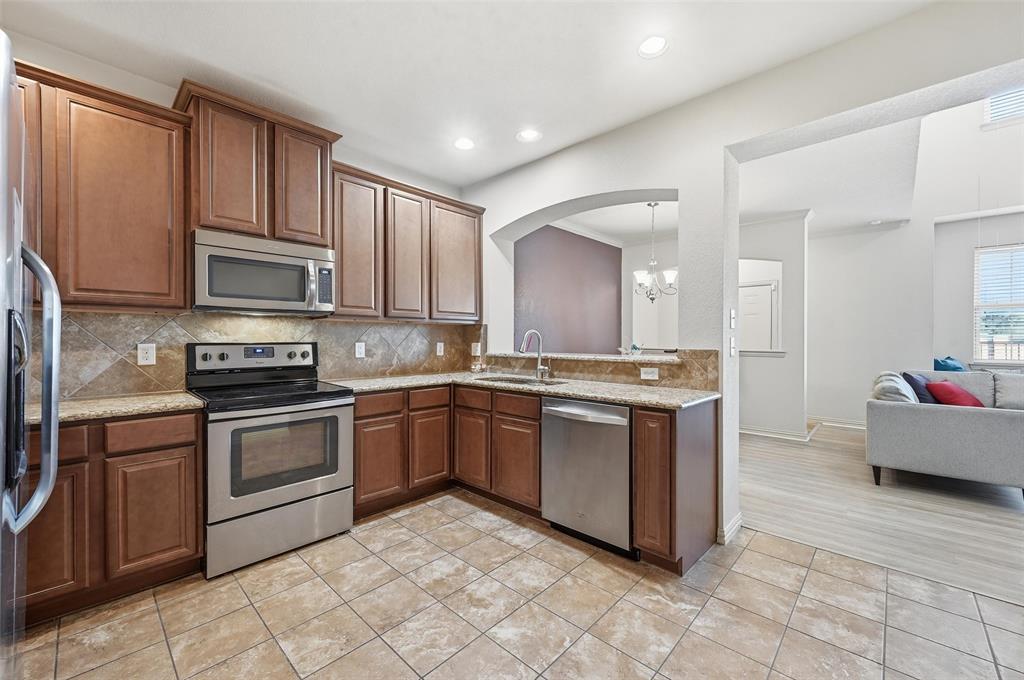 6913 Sandshell Boulevard Fort Worth, TX 76137 - Photo 13 of 24 a kitchen with stainless steel appliances granite countertop a stove top oven a sink dishwasher and a refrigerator