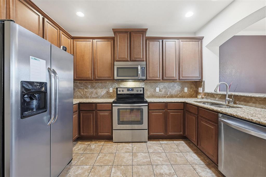 6913 Sandshell Boulevard Fort Worth, TX 76137 - Photo 14 of 24 a kitchen with stainless steel appliances granite countertop a refrigerator and a stove top oven