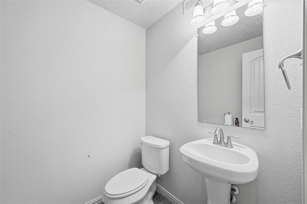 6913 Sandshell Boulevard Fort Worth, TX 76137 - Photo 18 of 24 a bathroom with a sink a toilet and a mirror