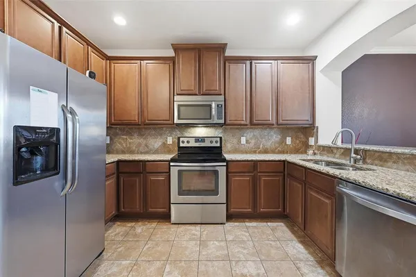 a kitchen with stainless steel appliances granite countertop a refrigerator sink and cabinets