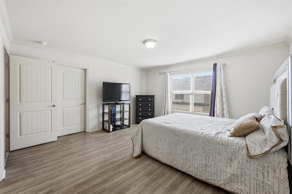 6913 Sandshell Boulevard Fort Worth, TX 76137 - Photo 4 of 24 a bedroom with a large bed and a tv