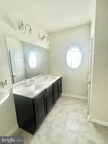 a bathroom with a sink vanity and mirror