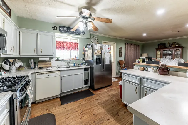 a kitchen with granite countertop a sink appliances cabinets and furniture