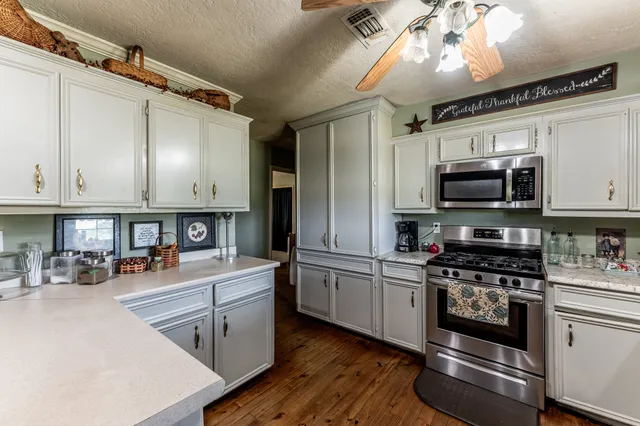 a kitchen with stainless steel appliances a stove sink microwave and cabinets