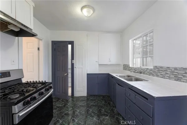 a kitchen with a sink stove and refrigerator