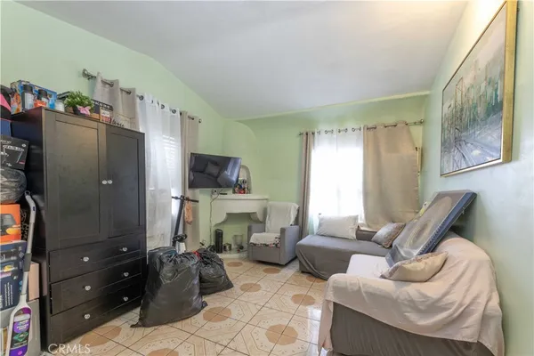 a bedroom with a bed and a flat tv screen on dresser