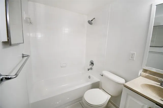 a white toilet sitting next to a bath tub