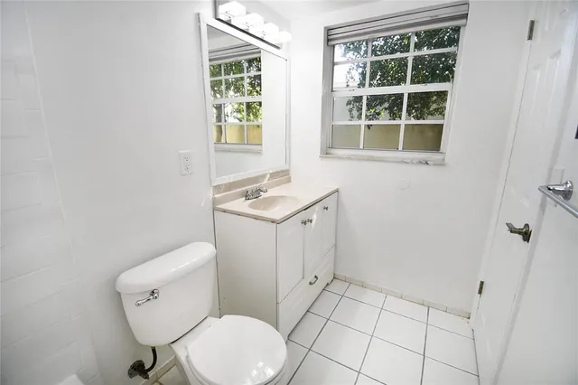 a bathroom with a toilet a sink and a window
