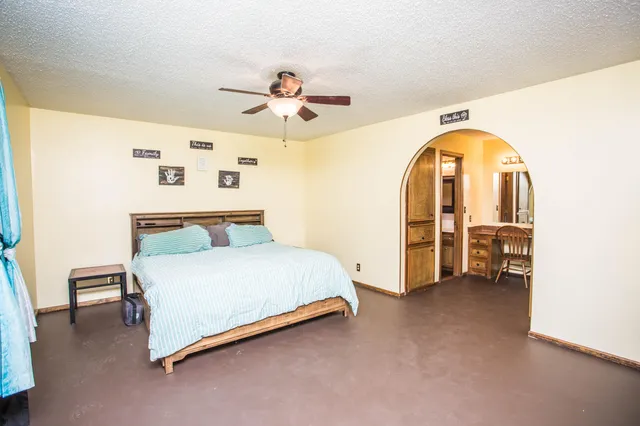 a spacious bedroom with a bed and a chandelier
