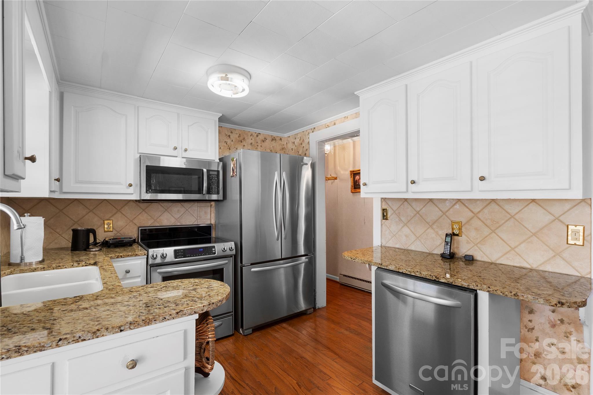 1687 Sexton Road, Unit 5 Denton, NC 27239 - Photo 11 of 48 a kitchen with granite countertop a refrigerator sink and wooden cabinets