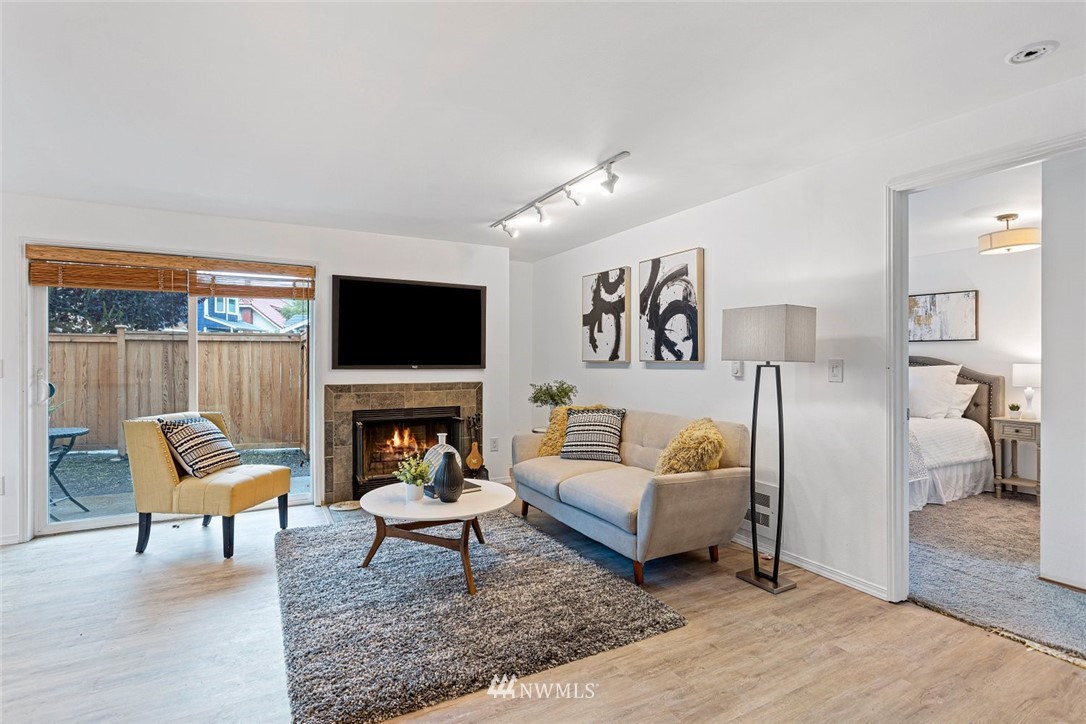 5909 Southwest Carroll Street, Unit 101 Seattle, WA 98116 - Photo 2 of 12 a living room with fireplace furniture and a flat screen tv