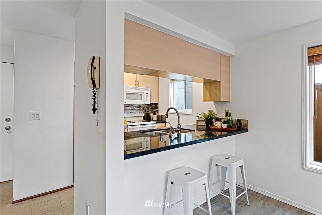 5909 Southwest Carroll Street, Unit 101 Seattle, WA 98116 - Photo 7 of 12 a kitchen with stainless steel appliances a sink and cabinets