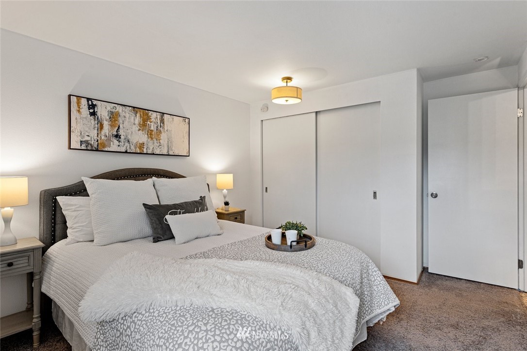 5909 Southwest Carroll Street, Unit 101 Seattle, WA 98116 - Photo 10 of 12 a bedroom with a bed and a painting on the wall