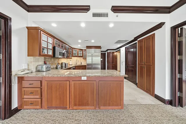 a kitchen with stainless steel appliances granite countertop a refrigerator and a stove top oven