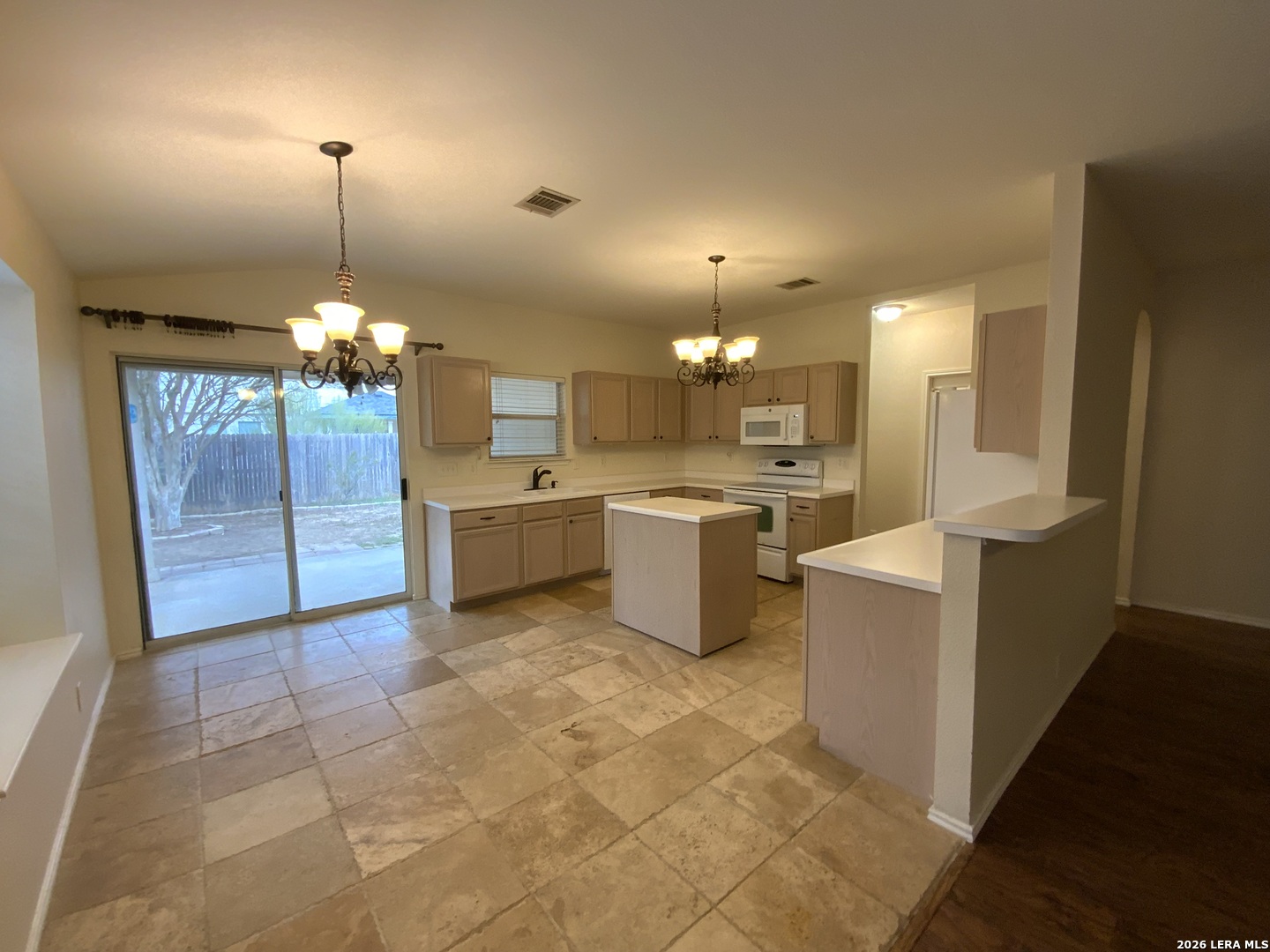9030 Pinseeker Selma, TX 78154 - Photo 6 of 16 a view of a kitchen with a sink wooden cabinets and a fireplace