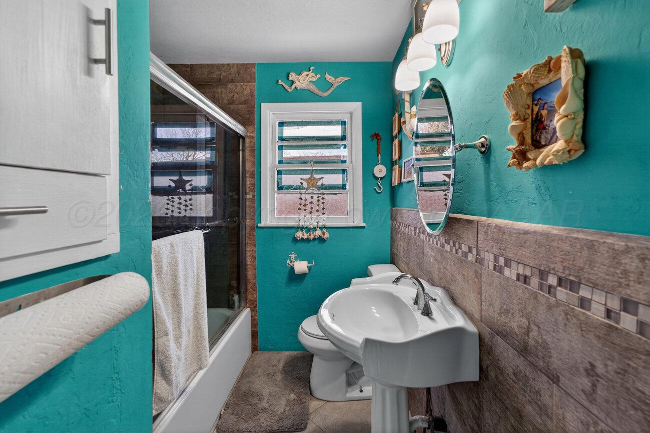 3508 Concord Road Amarillo, TX 79109 - Photo 9 of 12 a bathroom with a sink mirror and toilet