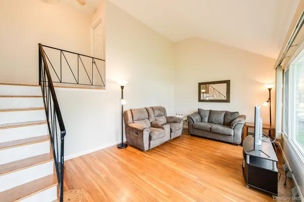 a living room with furniture and a wooden floor