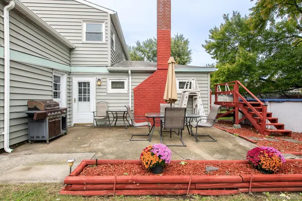 a backyard of a house with table and chairs