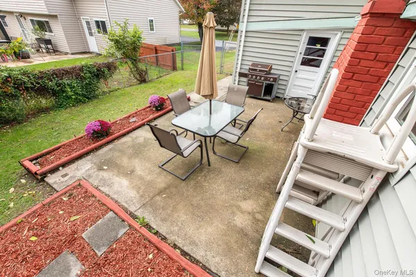 a view of a chairs and table in the back yard of the house