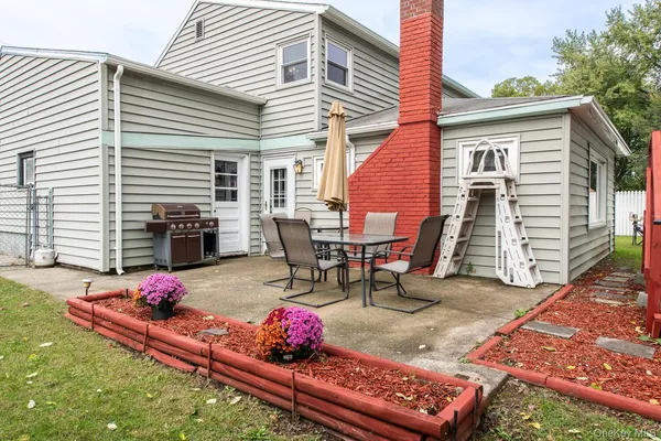 a view of backyard with table and chairs and wooden fence