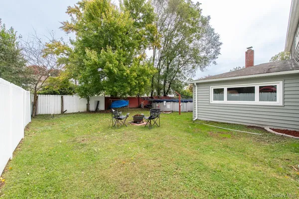 a backyard of a house with table and chairs