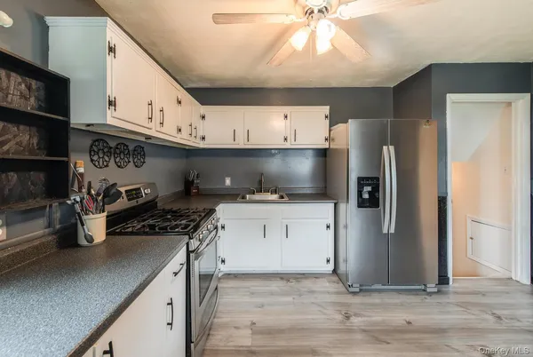 a kitchen with stainless steel appliances a stove refrigerator and cabinets