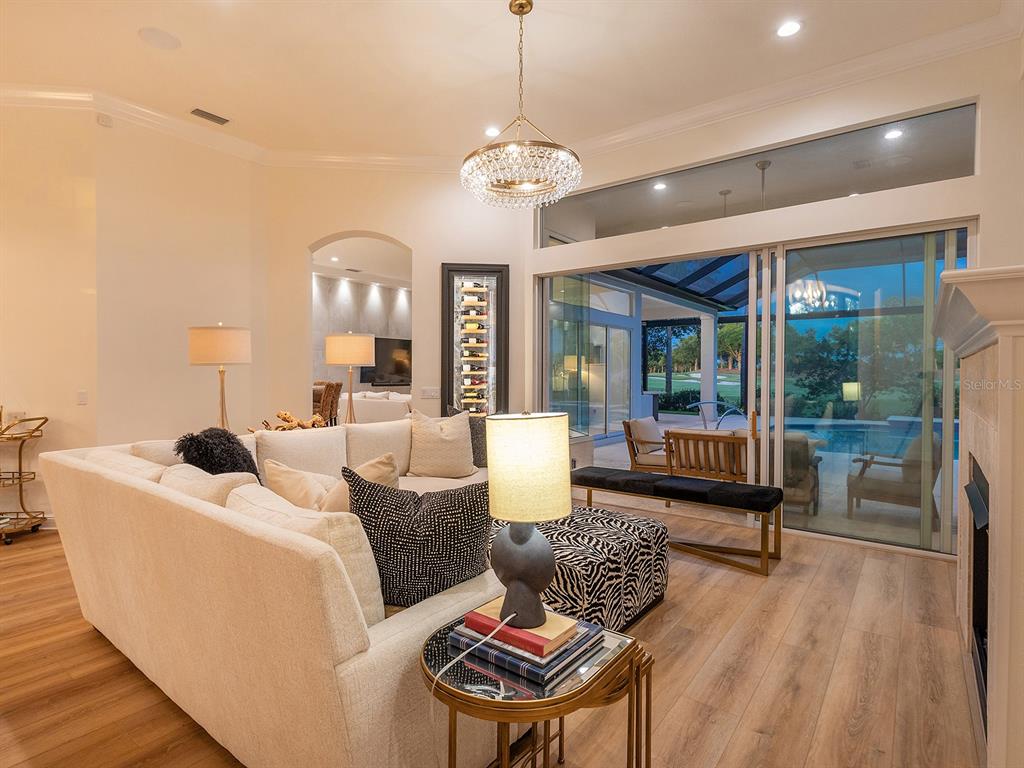 7431 Greystone Street Lakewood Ranch, FL 34202 - Photo 15 of 85 a living room with furniture a chandelier and a wooden floor
