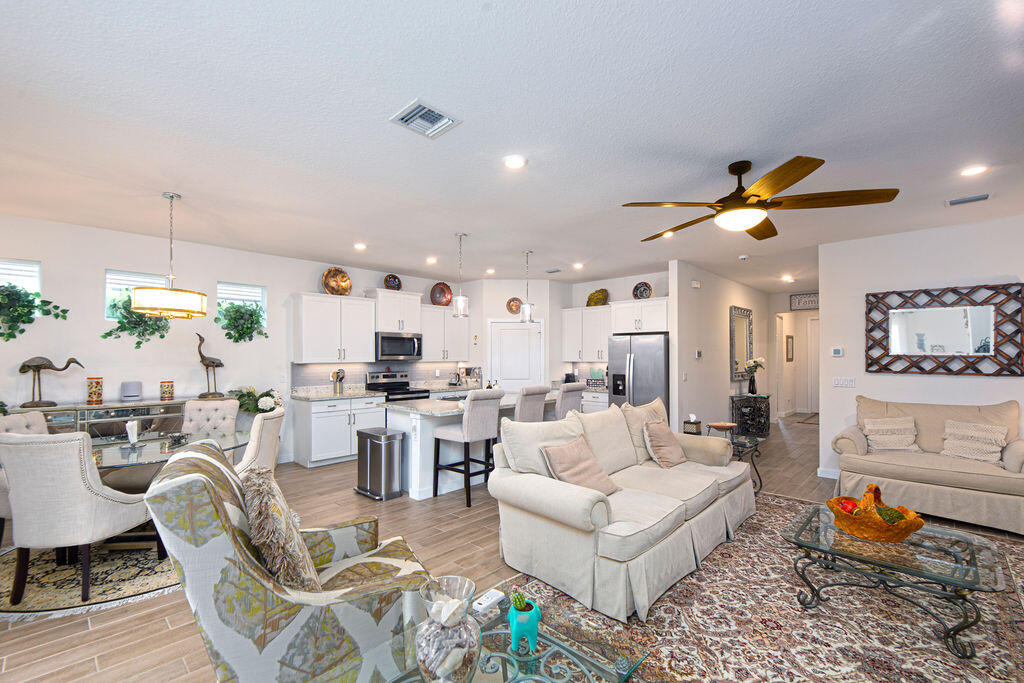 4480 Northwest Oakleaf Court Jensen Beach, FL 34957 - Photo 12 of 63 a living room with furniture kitchen view and a chandelier