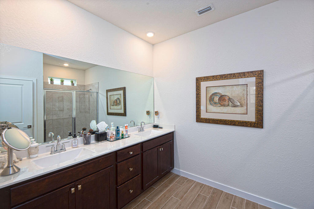 4480 Northwest Oakleaf Court Jensen Beach, FL 34957 - Photo 23 of 63 a bathroom with a double vanity sink and a mirror