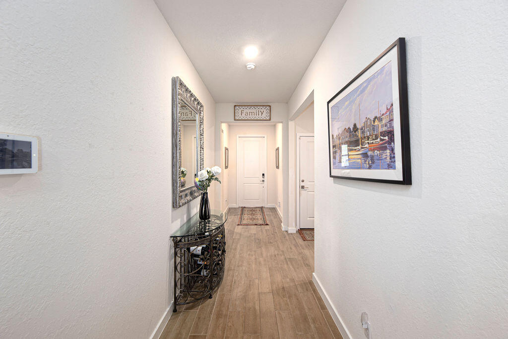 4480 Northwest Oakleaf Court Jensen Beach, FL 34957 - Photo 26 of 63 a view of a hallway with wooden floor and a bathroom