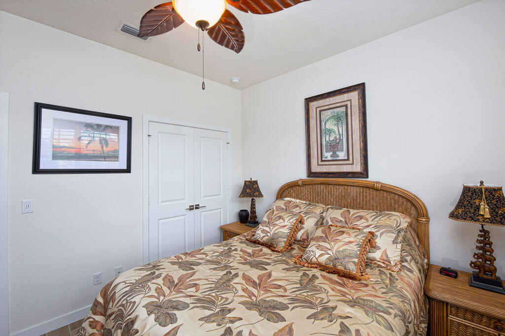 4480 Northwest Oakleaf Court Jensen Beach, FL 34957 - Photo 30 of 63 a bedroom with a bed and a painting on the wall