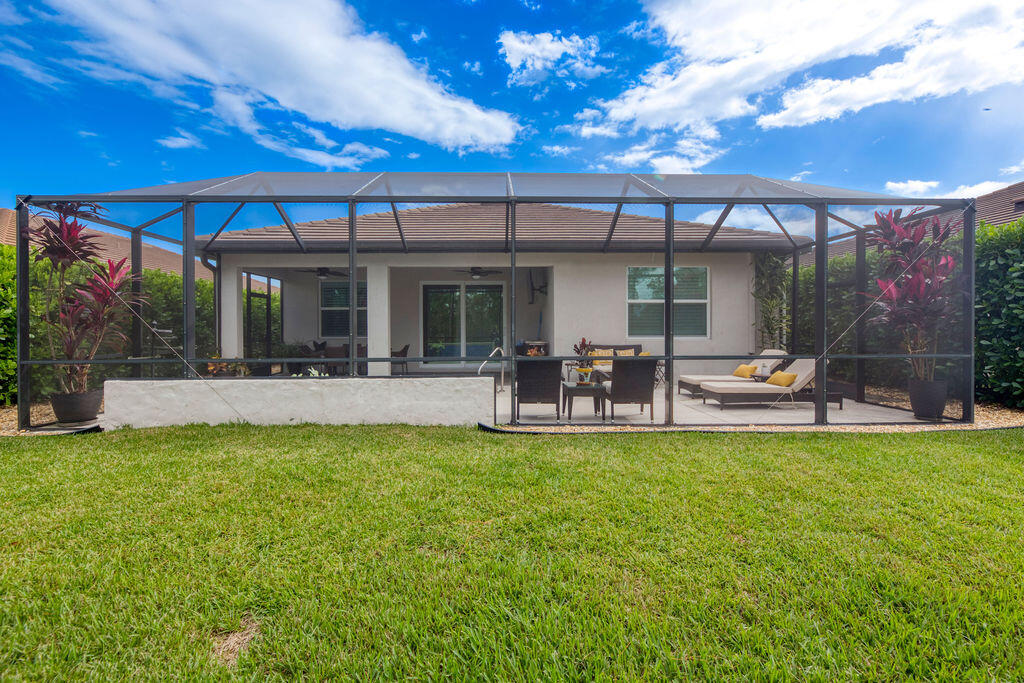 4480 Northwest Oakleaf Court Jensen Beach, FL 34957 - Photo 4 of 63 a view of a swimming pool with table and chairs under an umbrella