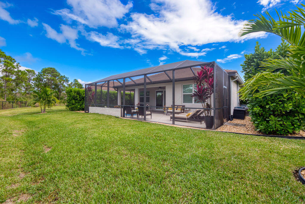 4480 Northwest Oakleaf Court Jensen Beach, FL 34957 - Photo 5 of 63 a view of a patio with table and chairs with a big yard