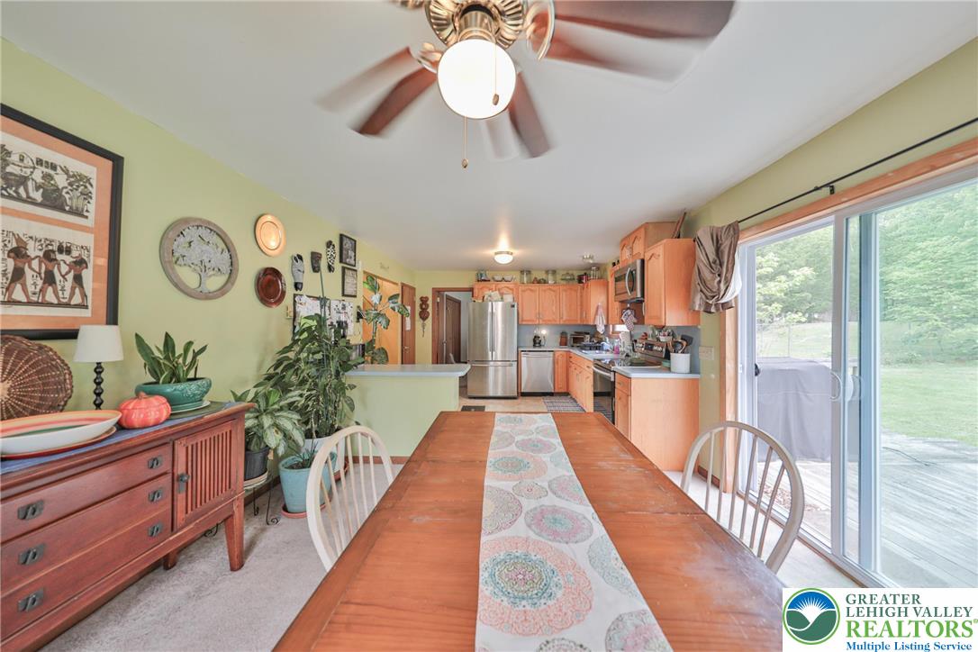 4608 Pine Ridge Drive West Bushkill, PA 18324 - Photo 62 of 62 An open floorplan combines kitchen and dining, illuminated by a ceiling fan and natural light from sliding glass doors.