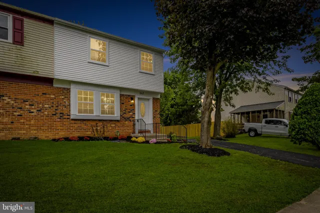 a front view of a house with a garden and trees